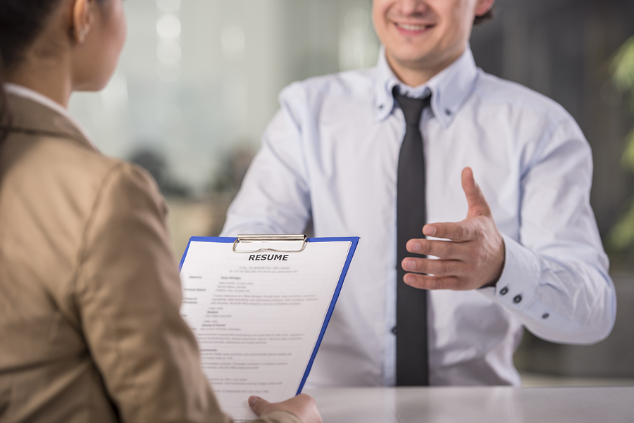 Businesswoman interviewing male candidate for job in office.