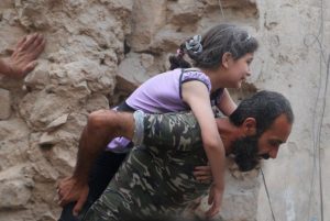A Syrian man carries a young girl to safety after airstrikes continued to pummel the Syrian city of Aleppo as the Syrian Civil War continues to rage for the fifth straight year.