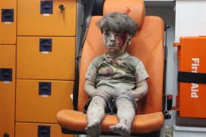 A little 4 year old Syrian boy waits patiently in an ambulance following a horrific rocket attack in the Syrian city of Aleppo. The boy was rescued from beneath the rubble of a destroyed building. His face seems to say everything there is to say about the five year old civil war that is ravaging Syria.