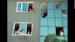 Residents of a Kabul apartment complex check out the damage done by a recent car bomb that exploded in front of their building.