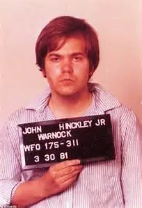 Hinckley, Jr. being booked and charged with the attempted murder of President Reagan.